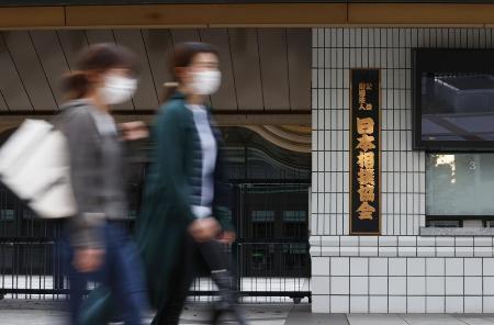 　東京・両国国技館の前を通るマスク姿の人たち