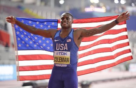 　世界陸上男子１００メートルで優勝し、笑顔で星条旗を掲げる米国のクリスチャン・コールマン＝２０１９年９月、ドーハ（共同）