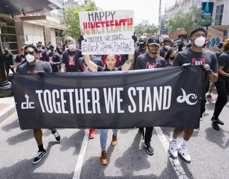 　ワシントンでＮＢＡウィザーズの選手とデモ行進するＷＮＢＡミスティックスのクラウド（中央）＝１９日、ワシントン（ＵＰＩ＝共同）
