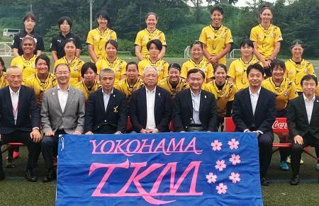 　横浜ＴＫＭの選手らと記念写真に納まる、日本ラグビー協会の森重隆会長（前列中央）＝１６日、横浜市