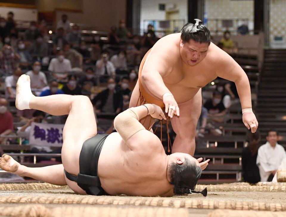 　隠岐の海（左）を突き落とし全勝キープの御嶽海（撮影・園田高夫）