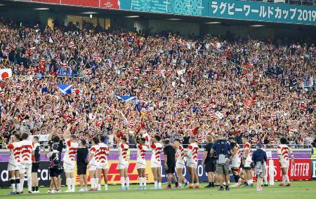 　ラグビーＷ杯１次リーグ最終戦でスコットランドを破って８強入りを果たした日本代表（下）に声援を送るファン＝２０１９年１０月、横浜市の日産スタジアム