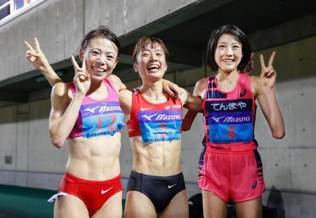 　女子１万メートルで優勝し、２位の松田瑞生（左）、３位の前田穂南（右）と笑顔を見せる鍋島莉奈＝熊谷スポーツ文化公園陸上競技場