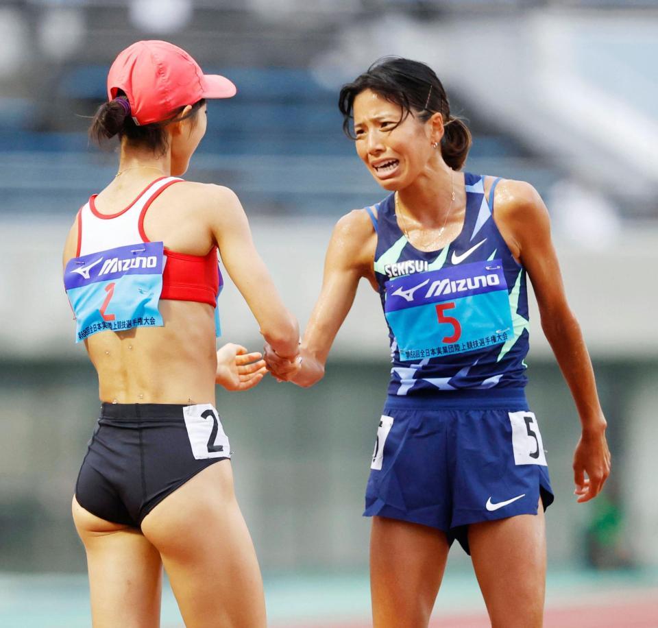 女子５０００メートルのレースを終え、健闘をたたえ合う２位の新谷仁美（右）と３位の広中璃梨佳＝熊谷スポーツ文化公園陸上競技場