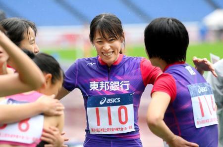 　日本選手権の女子１６００メートルリレー予選でラストランを終え、チームメートと健闘をたたえ合う東邦銀行の青木沙弥佳（中央）＝日産スタジアム