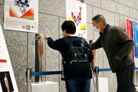 　展示された聖火リレーのトーチを見学する人たち＝２日午前、東京都庁