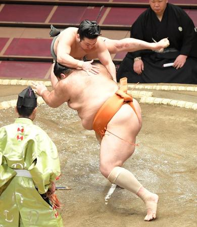 立合い直後に魁聖（手前）の横に飛ぶ炎鵬＝両国国技館（撮影・高石航平）