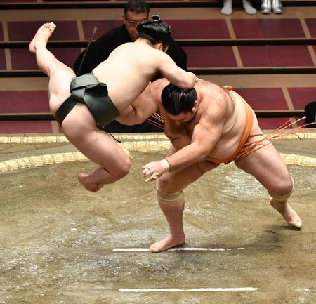 立ち合いで魁聖（右）に向かって飛び上がる炎鵬＝両国国技館（撮影・西岡正）