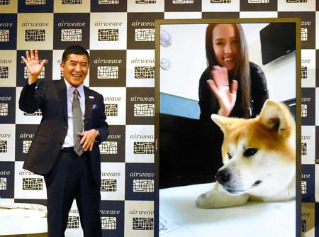 　株式会社エアウィーヴの高岡本州社長（左）と手を振るアリーナ・ザギトワと愛犬のマサル