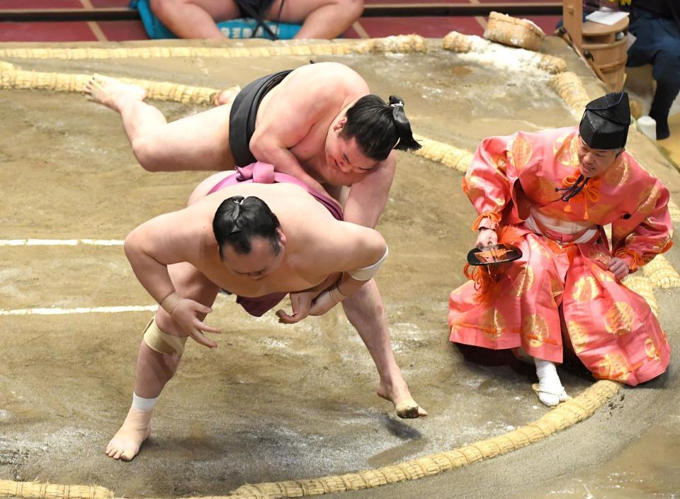 　宝富士（手前）を送り倒しで破る竜電。右は行司の木村晃之助（撮影・中田匡峻）