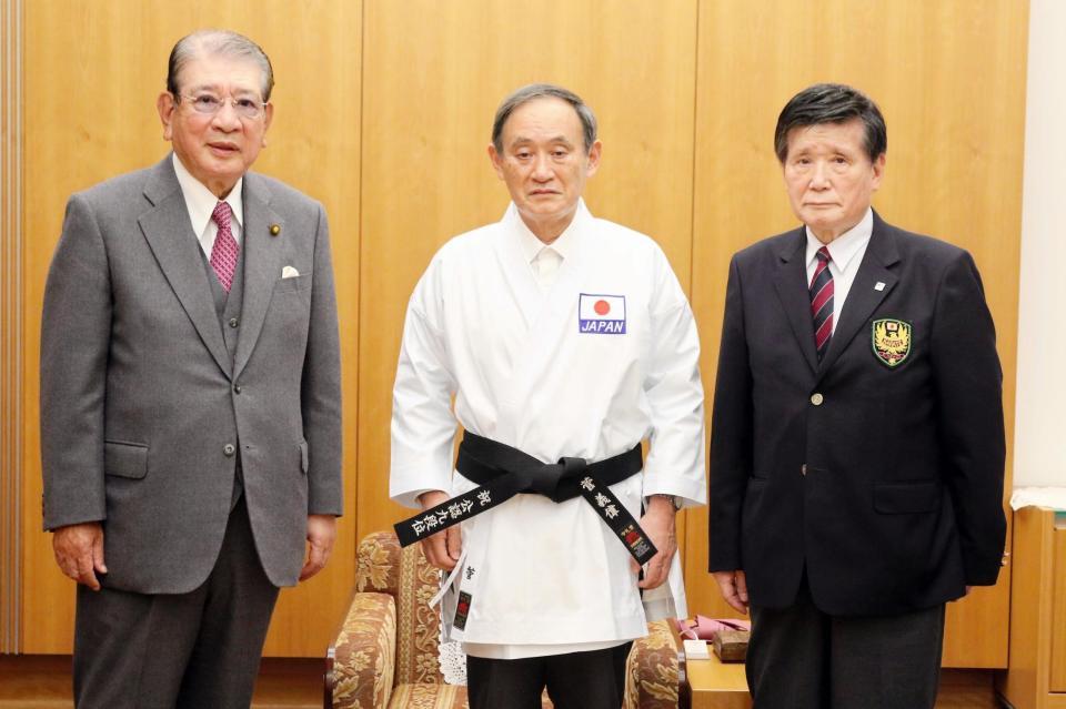記念の帯と空手着を贈られた菅義偉首相（中央）と笹川堯会長（左）、栗原茂夫副会長（全日本空手道連盟提供）