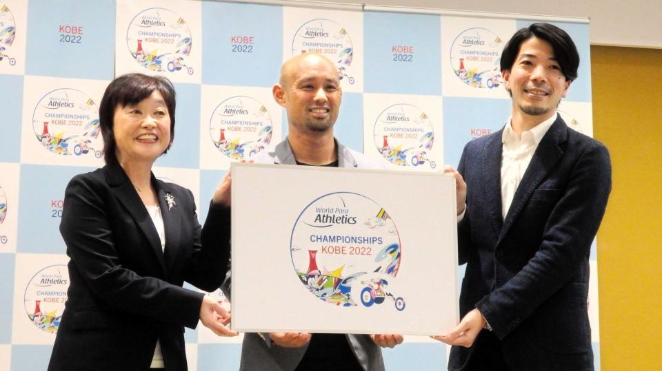 　大会ロゴを手に持つ（左から）増田会長、山本篤、ヨシ中谷氏