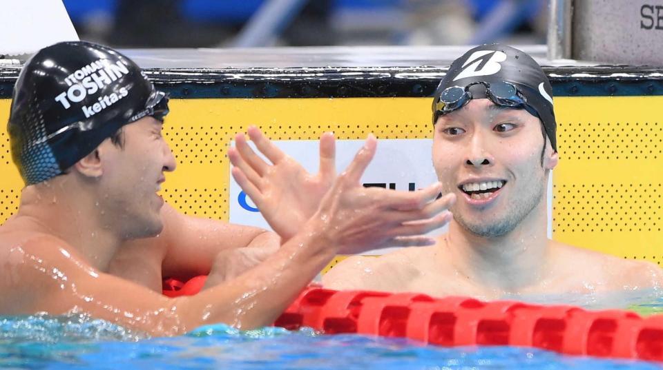 　優勝を決めてタッチを交わす萩野公介。左は砂間敬太（撮影・堀内翔）