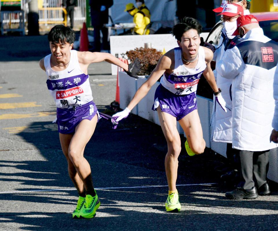 　戸塚中継所で駒大２区の田沢廉（右）からたすきを受け、駆けだす３区の小林歩