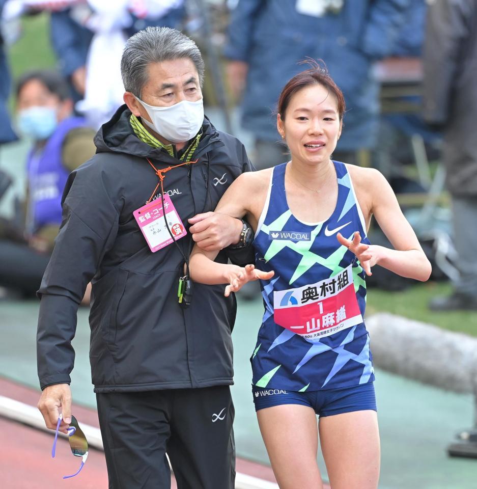 優勝し、ワコール・永山忠幸監督（左）に支えられる一山麻緒＝長居公園周回路（撮影・高部洋祐）