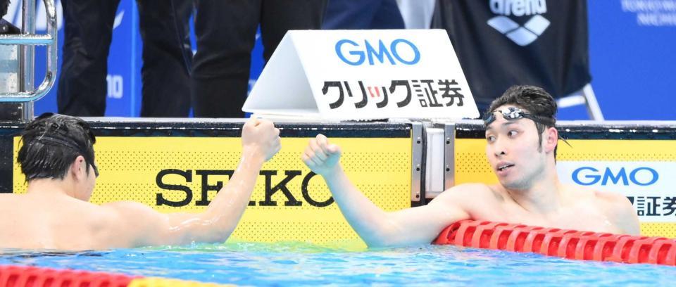 　８位の瀬戸（左）とタッチを交わす萩野（撮影・堀内翔）