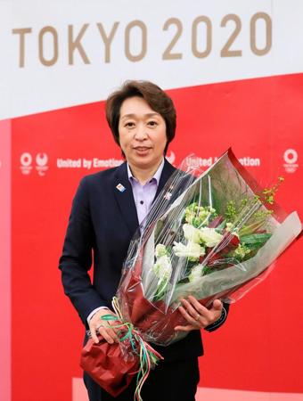 職員から贈られた花束を手に、記念撮影に応じる東京五輪・パラリンピック組織委員会の橋本聖子会長＝19日午後、東京都中央区（代表撮影）