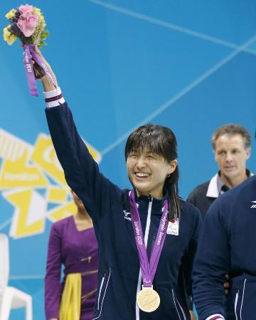 　女子１００メートル背泳ぎ（Ｓ１１）で獲得した金メダルを胸に、声援に応える秋山里奈さん＝２０１２年９月、ロンドン・パラリンピック