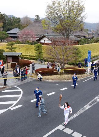 　現存する日本最古の学校とされる足利学校の前を走る聖火ランナー＝２８日午前、栃木県足利市