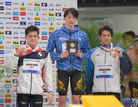 　男子５０メートル背泳ぎの表彰台に上がる（左から）２位の細川公平、優勝の入江陵介、３位の古賀淳也（撮影・高部洋祐）