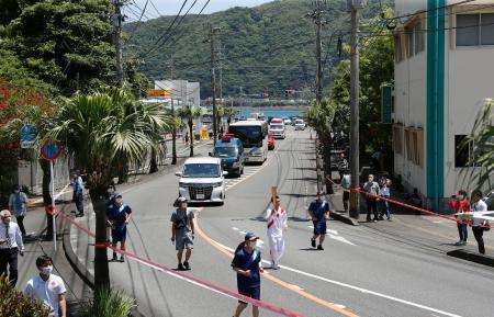 　鹿児島県・奄美大島でトーチを掲げて走る聖火ランナー＝２７日正午