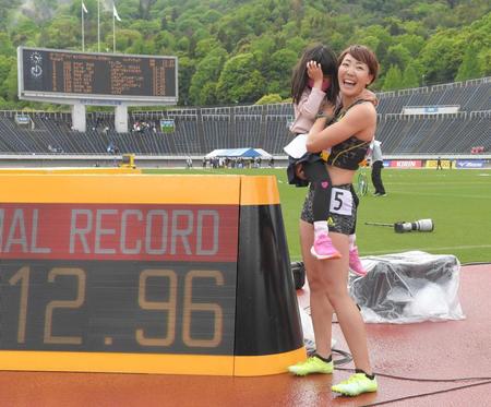 　１２秒９６の日本新記録を樹立し、時計の前で恥ずかしがる愛娘を抱く寺田明日香