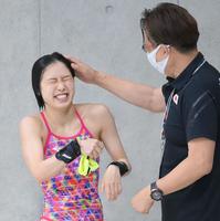 　女子高飛び込み準決勝５本目を終えて馬淵崇英コーチから頭をたたかれて祝福される荒井祭里（左）（撮影・堀内翔）