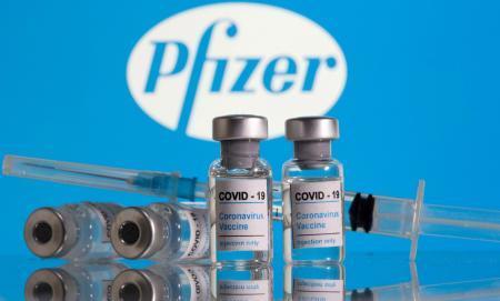 　ファイザー社のロゴと新型コロナウイルスワクチンのイメージ写真（ロイター＝共同）