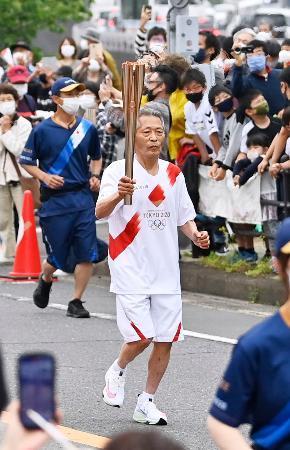 　長崎県長与町を走る聖火ランナーの栗山秋義さん＝８日午前