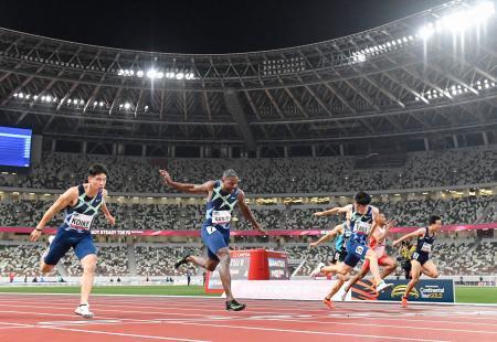 　陸上東京五輪テスト大会の男子１００メートル決勝でゴールする、（左から）３位の小池祐貴、優勝したジャスティン・ガトリン、２位の多田修平。緊急事態宣言下、無観客で行われた＝９日夜、国立競技場