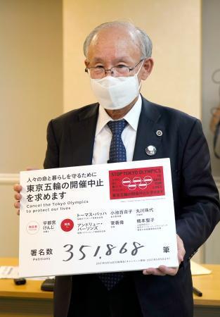 　集まった署名の数を書いたボードを手にする宇都宮健児氏＝１４日午前、東京都庁
