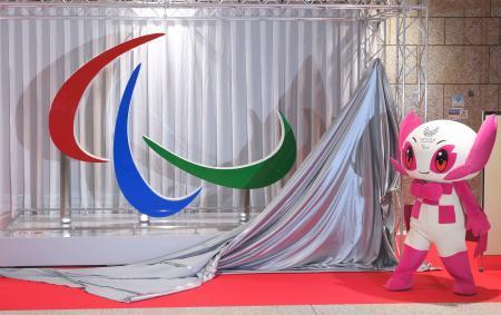 　東京パラリンピックの開催まで１００日となり除幕されたシンボルマーク「スリーアギトス」のモニュメント。右は大会マスコットの「ソメイティ」＝１６日午後、都庁（代表撮影）