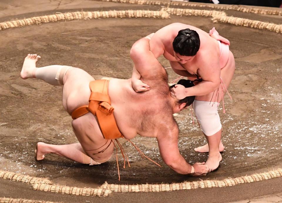 　幕内の土俵に上がった宇良がすくい投げで魁聖（左）を破る（撮影・園田高夫）