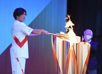 聖火皿に聖火を点灯する大畑大介氏＝兵庫県姫路市の姫路城三の丸広場（撮影・吉澤敬太）