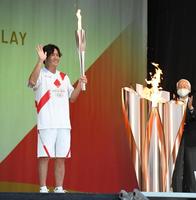 聖火を手に笑顔を見せる大畑大介氏＝兵庫県姫路市の姫路城三の丸広場（撮影・吉澤敬太）