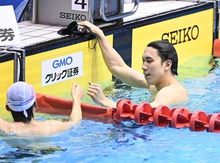　２００メートル自由形決勝を制し、３レーンの江原とグータッチをかわす松元克央（右）