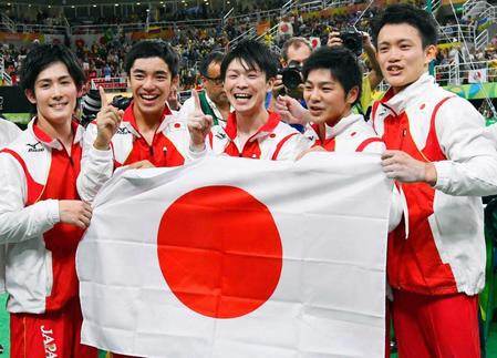 　２０１６年８月、リオ五輪体操男子団体総合で優勝を決め、日の丸を手に笑顔の白井健三（左から２人目）（共同）