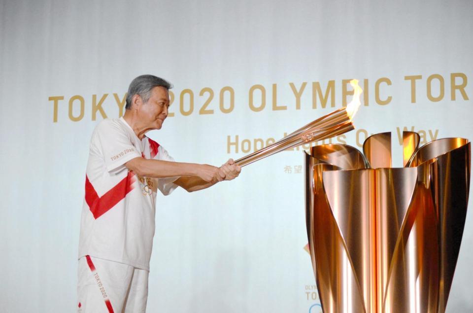 点火台に火をともす小倉智昭＝東京都立川市