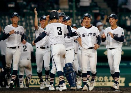 　小松大谷-高川学園　９回裏、山のサヨナラの押し出し四球で生還した三走隅田（３）を迎える高川学園ナイン＝甲子園