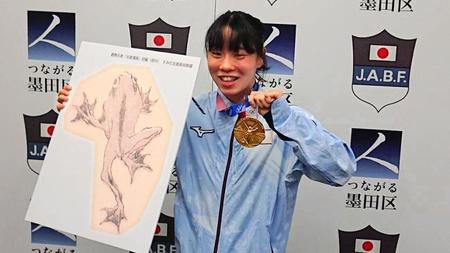 　葛飾北斎が描いたカエルのパネルを贈られて喜ぶ入江聖奈＝墨田区役所