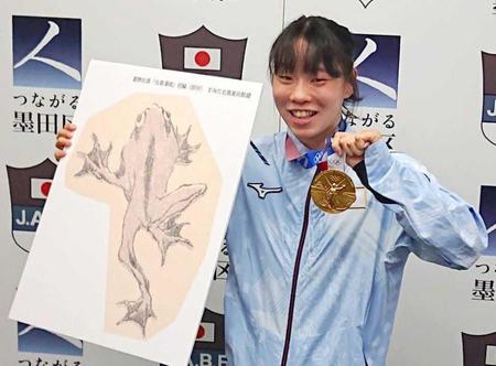 　葛飾北斎が描いたカエルのパネルを贈られて喜ぶ入江聖奈