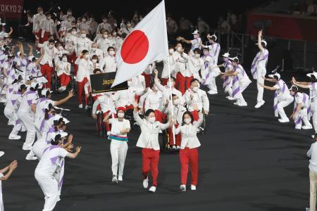 　東京パラリンピックの開会式で、旗手の岩渕幸洋（手前左）と谷真海を先頭に入場行進する日本選手団＝２４日夜、国立競技場