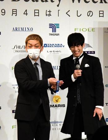 　レスリング乙黒拓斗（右）の金メダルを持たせてもらい感激するニューヨーク嶋佐