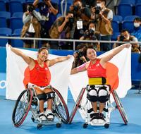 　女子ダブルス３位決定戦で中国ペアを破って銅メダル獲得を決め、笑顔で日の丸を掲げる上地結衣（左）、大谷桃子組＝有明テニスの森公園