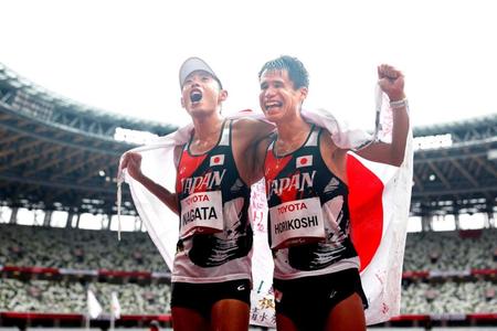 　マラソンで銅メダルを獲得し、日の丸を掲げて喜ぶ（左から）永田務と堀越信司