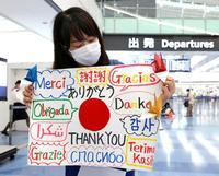 　帰国する海外選手団に感謝を伝えるボランティア＝６日午前、羽田空港