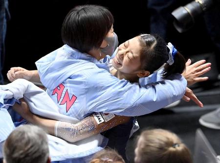 　女子種目別平均台決勝の演技を終え、村上茉愛（左）と抱き合う芦川うらら