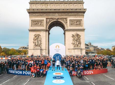 　パリ五輪開幕の千日前イベントに参加した男子マラソンのエリウド・キプチョゲ（中央）と一般ランナー＝３１日（パリ五輪組織委員会提供・共同）