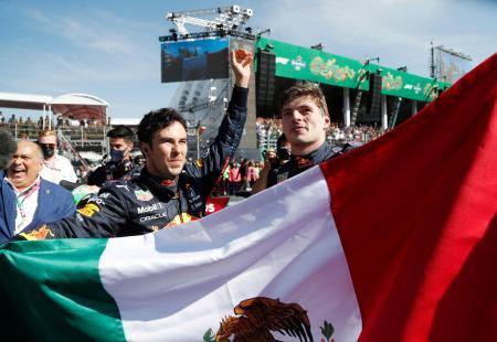 　地元メキシコでの表彰台に笑顔のセルヒオ・ペレス（左）とともに、メキシコ国旗を掲げるマックス・フェルスタッペン＝７日、メキシコ市（ロイター＝共同）
