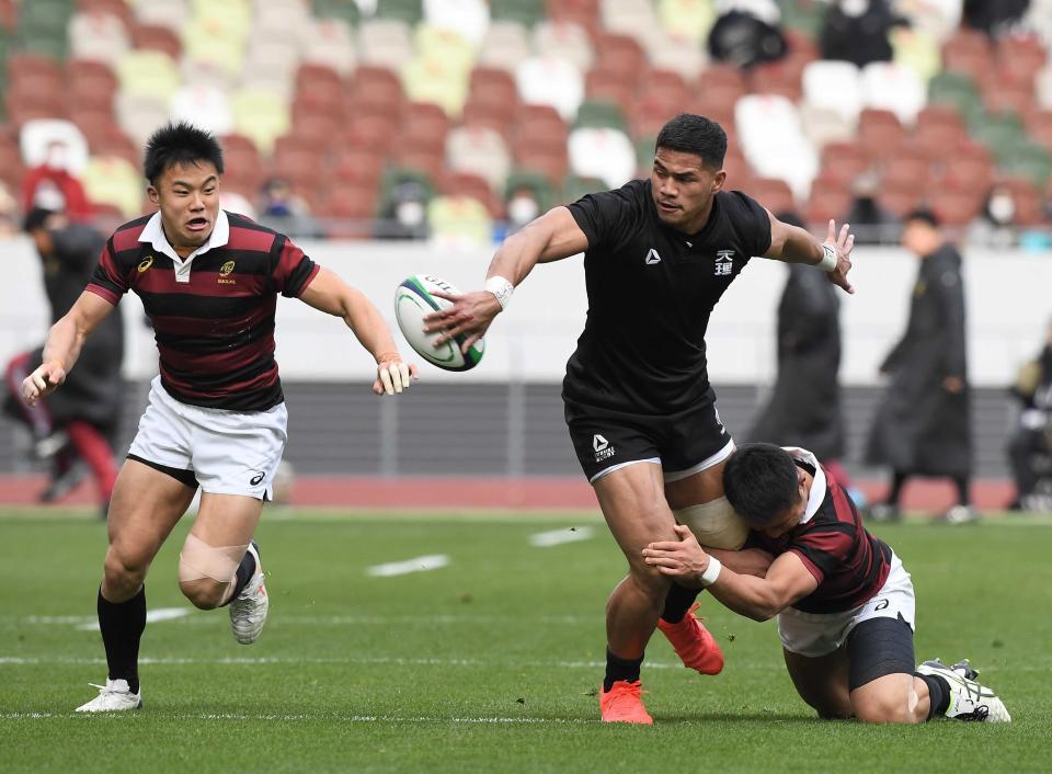 　２１年１月、大学選手権決勝　優勝の天理大・フィフィタがタックルを受けながらオフロードパス